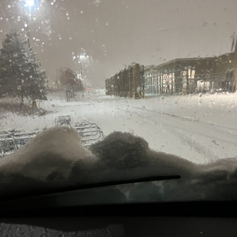 Snowy street viewed through car windshield