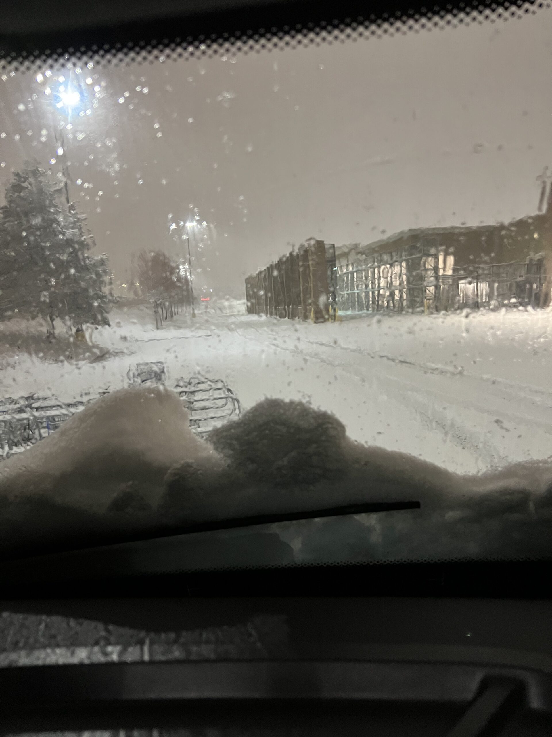 Snowy street viewed through car windshield