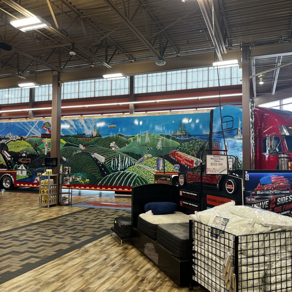 Large mural-covered semi-truck parked inside the Iowa 80 showroom