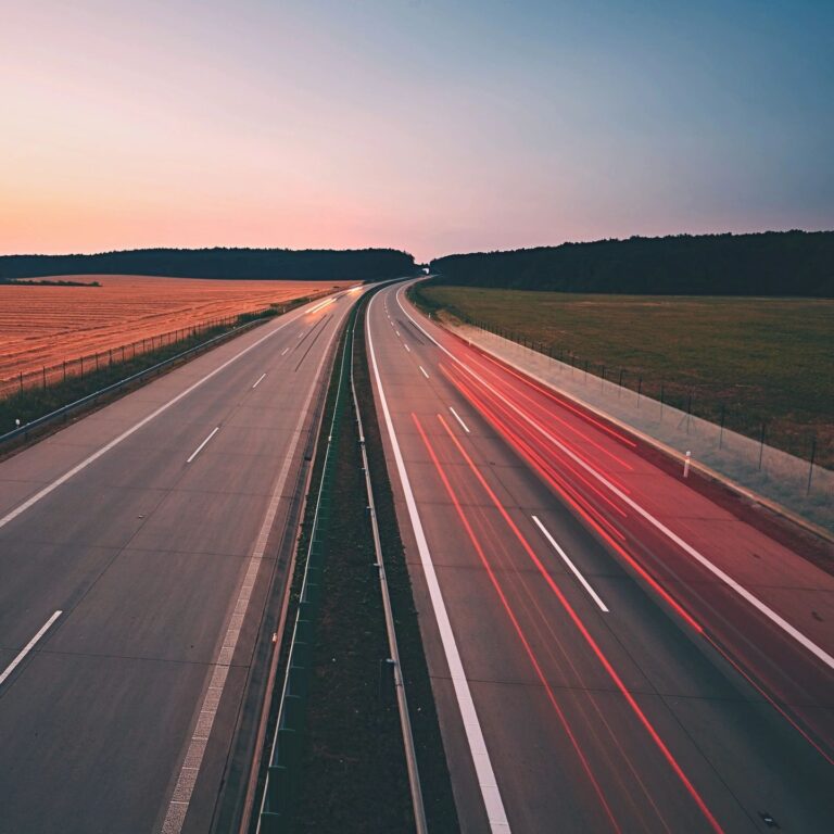 Empty highway with car light trails at dusk