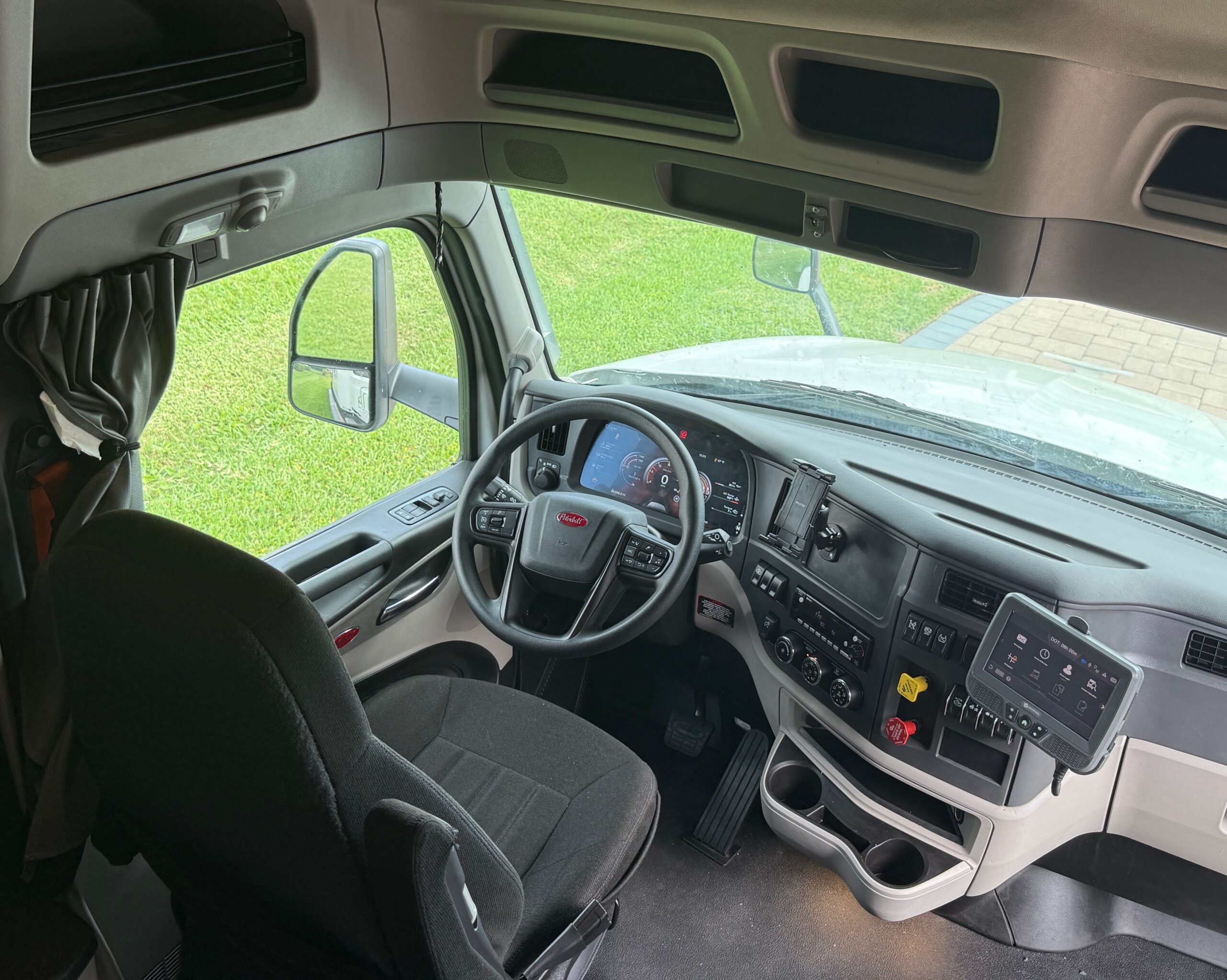 M2GT Inside view of a truck driver's cabin with dashboard and steering wheel.