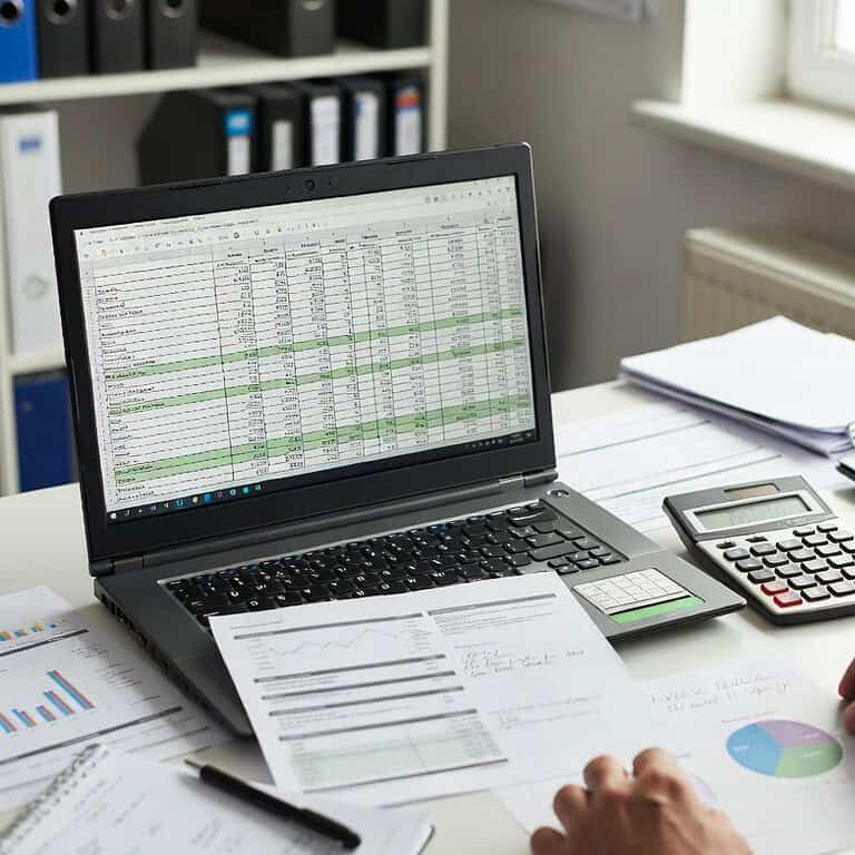 Truck driver reviewing tax documents and finances on a laptop.